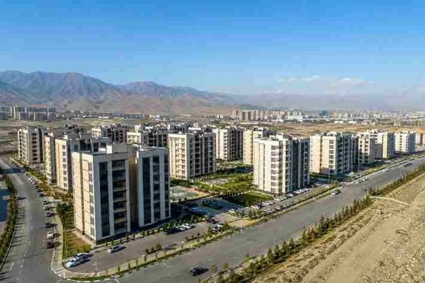 مدیریت در آپارتمان‌های پردیس، مجتمع مسکونی بزرگ، بلوک‌های مرتب، نمای مدرن، آسمان آبی، کوه در پس‌زمینه، نمای هوایی، رئال